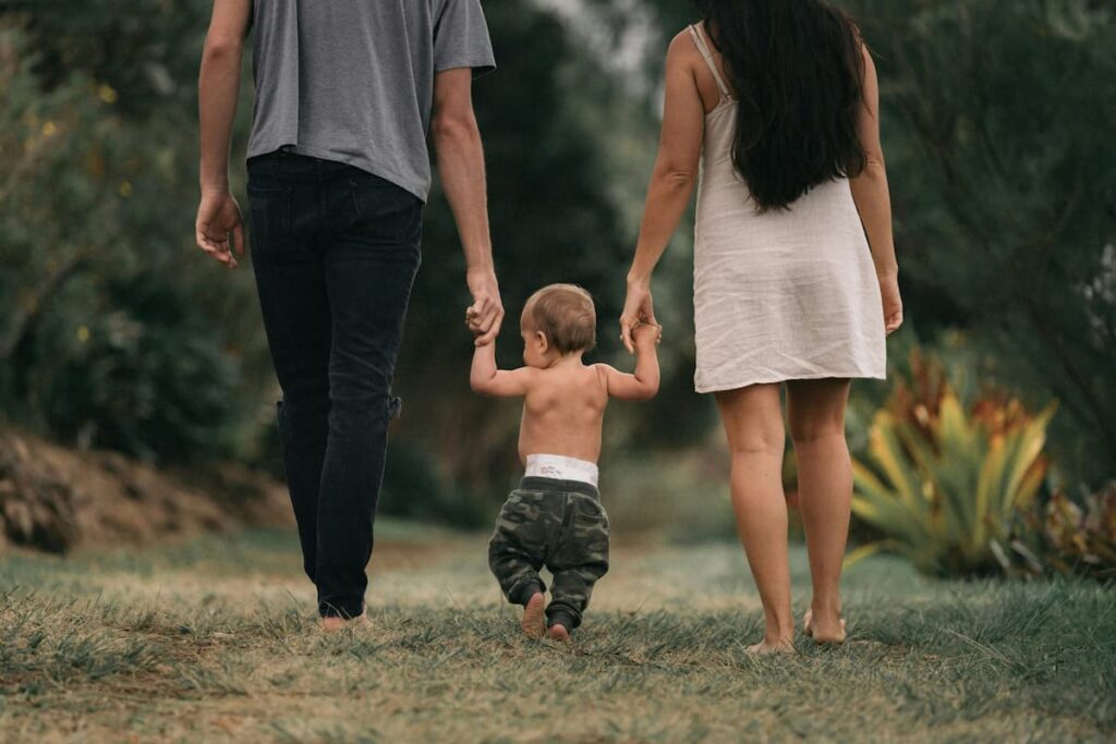 Parents walking with their child symbolizing guidance on the journey to financial literacy and future savings